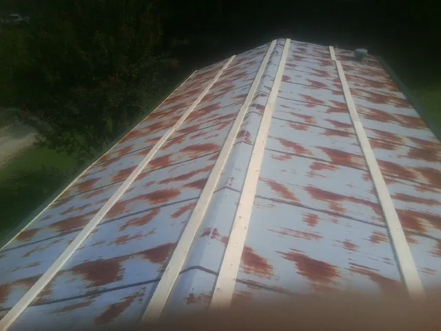 Rusted metal roof panels with new wood purlins before replacement — Storm Damage Roof Repair in Merlin by Roofing Brothers