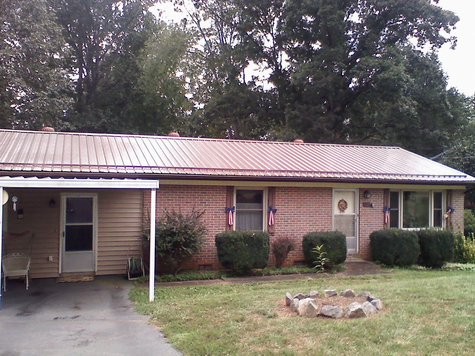 Bronze metal roof and carport on a brick ranch home — Roof Repair work by our crew in Merlin